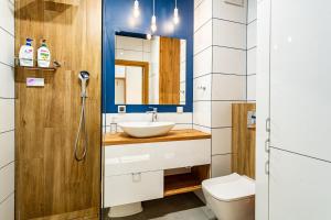 a bathroom with a sink and a toilet at Apartament Yacht Park Marina in Gdynia