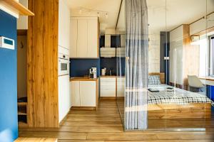 a bedroom with a bed in a room with a kitchen at Apartament Yacht Park Marina in Gdynia