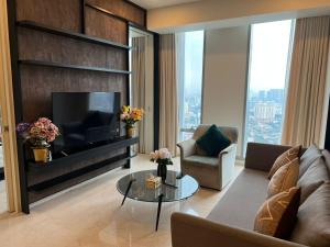 a living room with a television and a couch and a table at Tropicana The Residence KLCC By Rainbow Suites in Kuala Lumpur