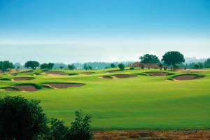 a view of a golf course with green grass at Capital Coast Resort And Spa in Paphos