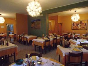un comedor con mesas, sillas y lámparas de araña en Hotel Cristina, en Chianciano Terme