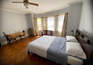 1 dormitorio con 1 cama, mesa y sillas en Spacious Bedroom in a Brooklyn House Shared with Host, en Brooklyn