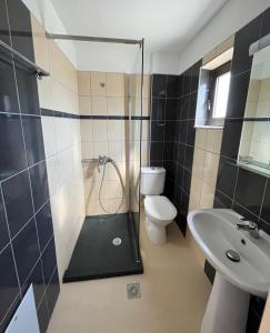 a bathroom with a shower and a toilet and a sink at Angelos Studios in Kos