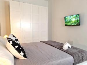 a bedroom with a bed with a television on the wall at Glam House Assemini in Assemini