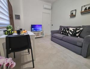 ein Wohnzimmer mit einem Sofa und einem Tisch in der Unterkunft Glam House Assemini in Assemini