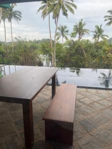 米瑞莎的住宿－Atulya Lake View - Resort and Spa，木凳,坐在水体旁边