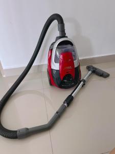 a vacuum sitting on a white floor with a hose at My Homestay @ Morib Bay Banting in Banting