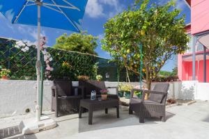 a patio with chairs and a table and an umbrella at Happy Holiday Sintra in Sintra