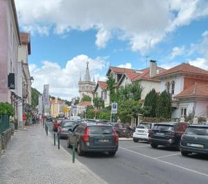una strada cittadina con auto parcheggiate sul lato della strada di Happy Holiday Sintra a Sintra