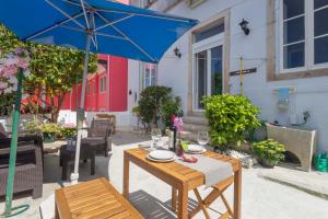 a table with a blue umbrella on a patio at Happy Holiday Sintra in Sintra