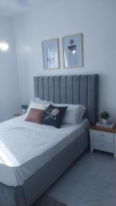 Bett mit grauem Kopfteil in einem Schlafzimmer in der Unterkunft C.leslie_homes in Bamburi