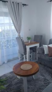 uma sala de estar com uma mesa e um sofá em C.leslie_homes em Bamburi