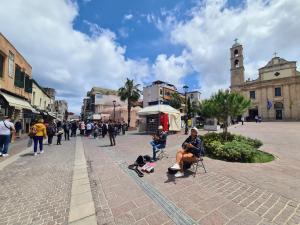 een groep mensen die in stoelen op straat zitten bij Nikolas Rooms in Chania