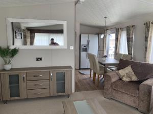 a living room with a couch and a table at Beautiful 6 Berth Caravan By The Beach In Suffolk Ref 40076nd in Lowestoft