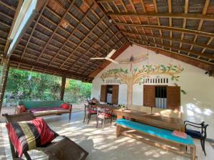 a living room with a wooden ceiling with a tree on the wall at Dragon-Fly Home Hikka in Dodanduwa