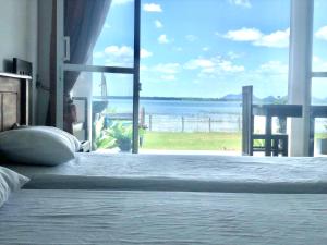 a bedroom with a bed with a view of the ocean at Lapwing Lake Villa in Tissamaharama