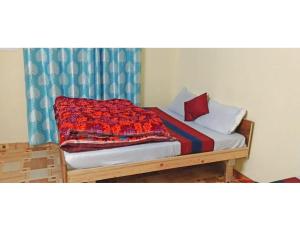 een bed met een rode deken erop bij Hotel Amandeep Galaxy, Barkot in Barkot