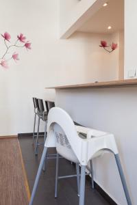 eine Bar mit weißen Stühlen und Blumen an der Wand in der Unterkunft Ferienwohnung Holzstraße in Fürth