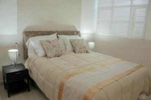 Un dormitorio con una cama grande con almohadas. en Cholula 85, en Ciudad de México
