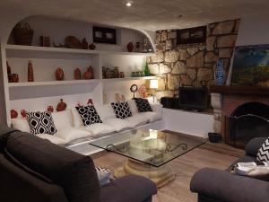 salon z kanapą i kominkiem w obiekcie El Campillo w mieście Pelabravo