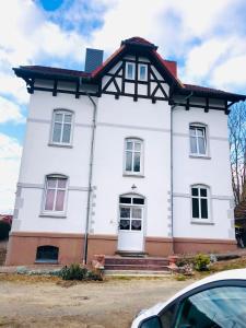 une maison blanche avec un toit en gambrel dans l'établissement Ferienhof - Ferienwohnung, à Gadebusch
