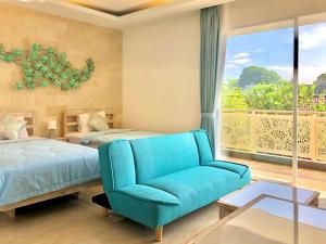 ein Schlafzimmer mit einem blauen Sofa, einem Bett und einem Fenster in der Unterkunft Ocean Star Apartment Sanur in Sanur + 37 Fotos