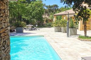 una piscina frente a una casa en LA VILLA DU PETIT BOIS Les Lavandes, en Faucon