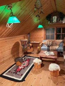 a living room with a couch and a guitar in a cabin at ぜーんぶ貸切!! 大自然の森に佇む秘密の隠れ家で心と身体を解放する... in Yuzawa