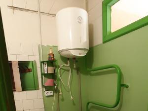 a bathroom with a toilet with a light on the wall at Эконом вариант - спальный район in Chernihiv
