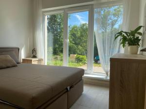 um quarto com uma cama e uma grande janela em Spacious cosy house in Vilnius em Vilnius