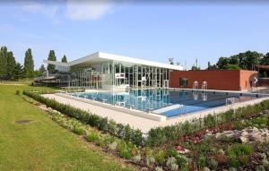 un bâtiment avec une piscine à côté d'un jardin dans l'établissement Comme chez vous, à Strasbourg