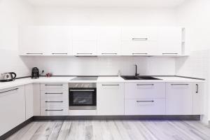 a white kitchen with white cabinets and an oven at Elegant Apartment in Milan
