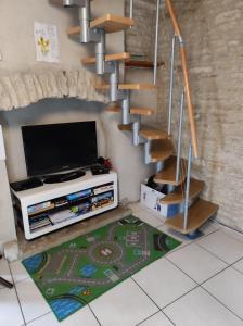 una sala de estar con TV y un conjunto de escaleras en Holiday home Aqueducienne, en Ahuy