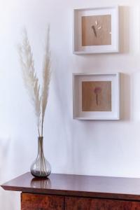 a vase on a table with two pictures on the wall at Elegant Apartment in Milan
