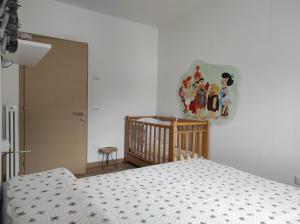 een slaapkamer met een bed en een wieg bij Appartamento Wilma in Spormaggiore