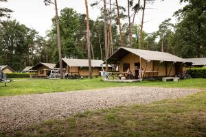 a group of lodges with a tent in a field at Familiepark Goolderheide in Bocholt