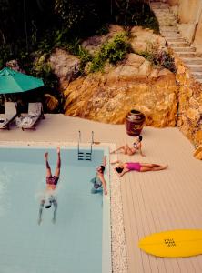 a group of people laying in a swimming pool at Villa SPACE in Unawatuna