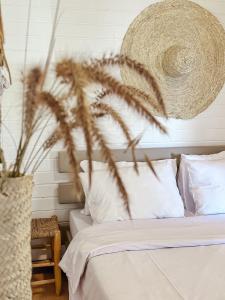 Un dormitorio con una cama con sábanas blancas y una planta en Sky Travelers סקיי מטיילים, en Ramot