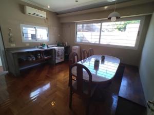a kitchen with a table and chairs and a stove at Casa Azcuénaga - Parque - Zona comercial - Aerop 15 min in Monte Grande