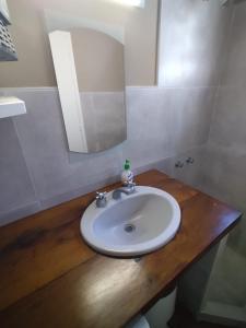 y baño con lavabo blanco y espejo. en Casa Azcuénaga - Parque - Zona comercial - Aerop 15 min en Monte Grande