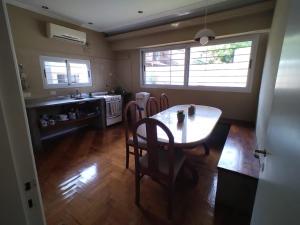 una cucina con tavolo e sedie in una stanza di Casa Azcuénaga - Parque - Zona comercial - Aerop 15 min a Monte Grande