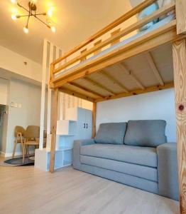 uma sala de estar com um sofá e um loft em GBU's Studio with Balcony at Azure North Pampanga em San Fernando