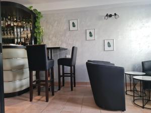 un bar con sedie nere e tavoli in un ristorante di Hotel Keltika a Izola