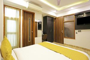 a hotel room with a bed and a television at Hotel LA CASA DELHI AIRPORT in New Delhi