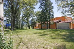 einen Hof mit Bäumen und ein Gebäude mit Garage in der Unterkunft Garni Hotel Siesta in Nova Gorica