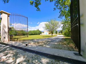 an open gate to a driveway with a yard at Cante Grillet in Lacoste