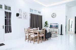 a white living room with a table and chairs at Pilla Villa Purwokerto in Purwokerto