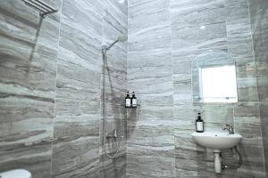 普禾加多的住宿－Pilla Villa Purwokerto，带淋浴、盥洗盆和镜子的浴室