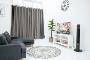 a living room with a couch and a tv at Pilla Villa Purwokerto in Purwokerto