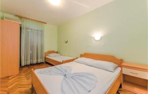 a bedroom with a large bed with white sheets at 2 Bedroom Gorgeous Apartment In Bosana in Stan Trigraci